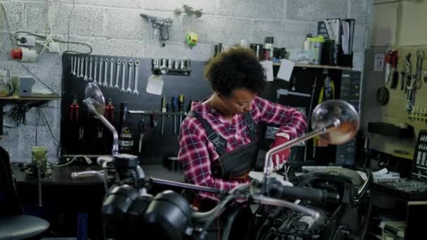 Mécanicien afro-américain réparant une moto dans un atelier — Video