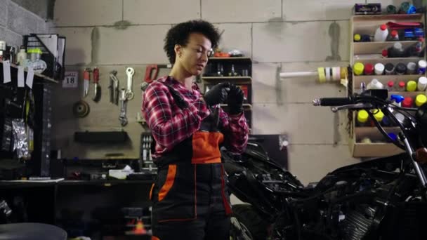 Африканская американка-механик ремонтирует мотоцикл в мастерской — стоковое видео