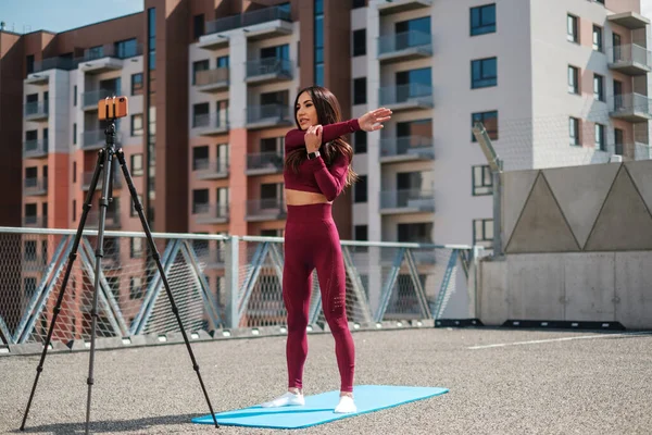 Женщина делает онлайн тренировки на открытом воздухе — стоковое фото