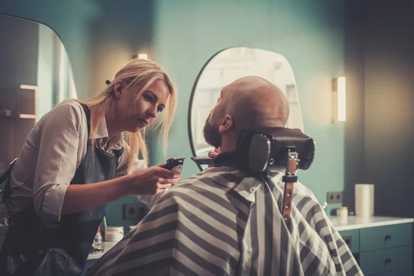Barber maakt zich klaar om de baard door te snijden met nieuwe elektrische trimmer. — Stockfoto