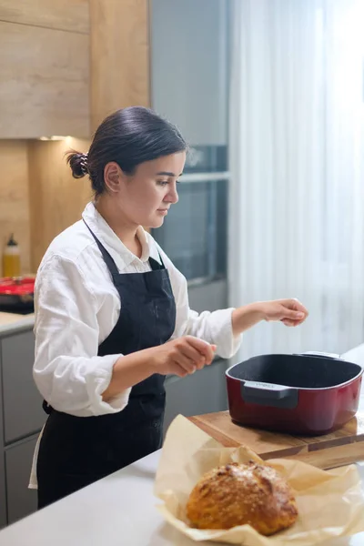 Baker tog ut bröd från bakning maträtter. — Stockfoto