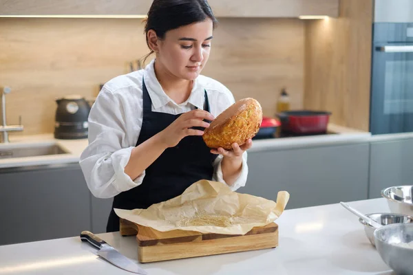 Aantrekkelijke Baker Meisjes checkt brood voor paraatheid. — Stockfoto