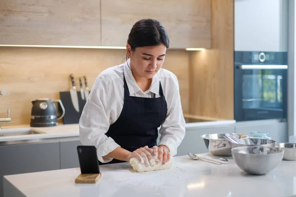 Vrouwelijke Kneads Dough op bloemrijke tafel. — Stockfoto