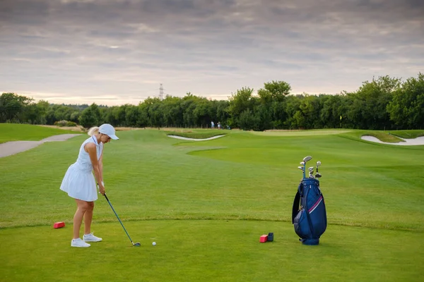 Mujer centrada en golpear la pelota de golf . — Foto de Stock