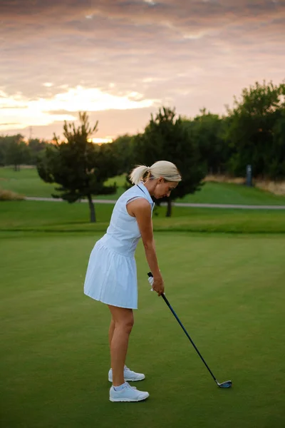 Golfista profesional mujer centrada en golpear la bola . — Foto de Stock