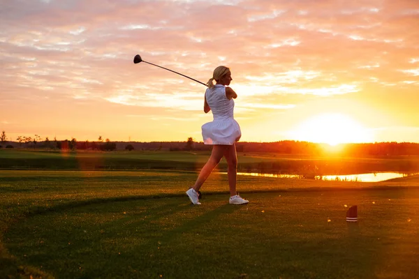 Lady spela golf med solnedgång bakgrund . — Stockfoto