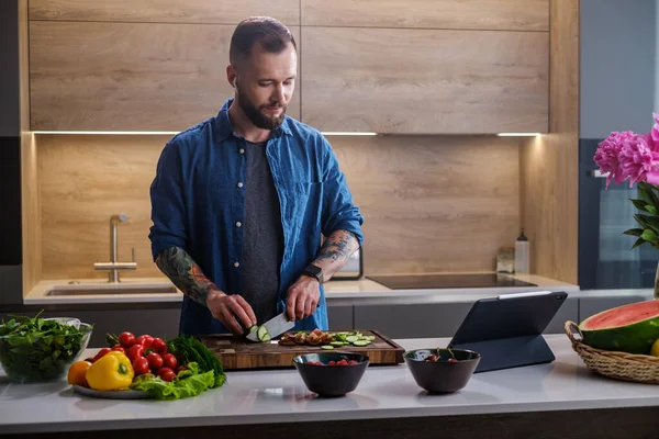 Aantrekkelijke man luisteren naar muziek tijdens het koken . — Stockfoto