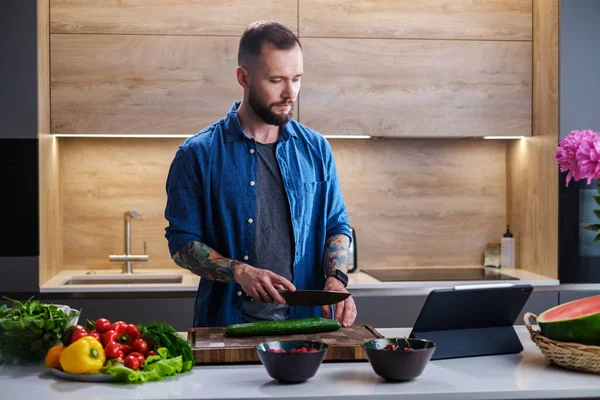 Knappe man gesneden verse groenten voor salade . — Stockfoto