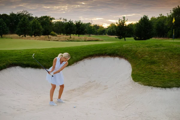 Atlética hembra golpeó pelota de golf desde el lugar duro . — Foto de Stock