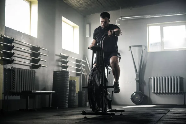 Mann macht hartes Beintraining auf stationärem Fahrrad . — Stockfoto