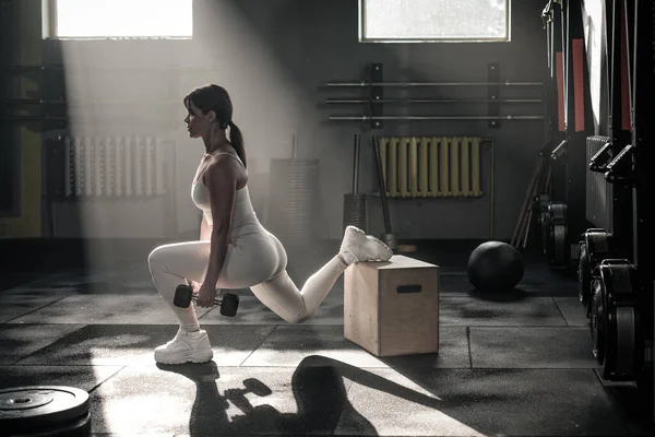 Легкоатлетка использует гантель для упражнений на корточках . — стоковое фото