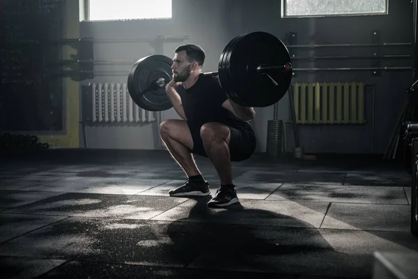 Homem qualificado fazer agachamentos com Barbell . — Fotografia de Stock