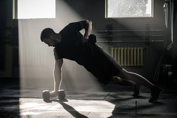 Hombre fuerte hacer push ups con dumbbell . —  Fotos de Stock