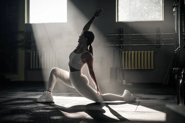 Spor yapmadan önce vücut esneme hareketleri yapan atletik kadın. . — Stok fotoğraf