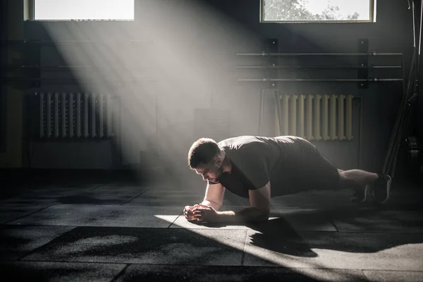 Sportsman Hold Plank Pose en el gimnasio masculino . — Foto de Stock