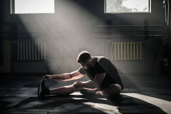 Sportman doet benen strekken in de sportschool . — Stockfoto