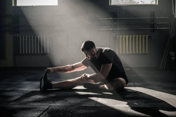 El hombre atlético estira sus piernas . — Foto de Stock