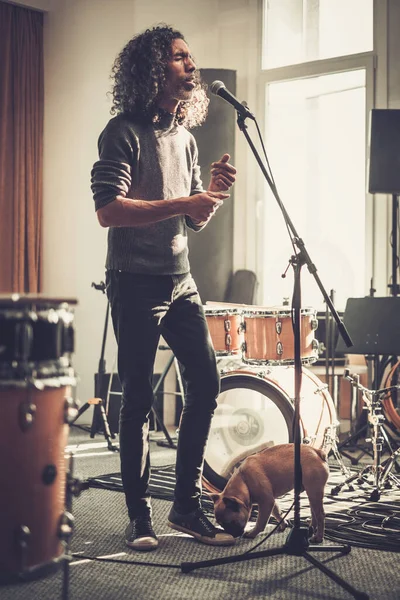 Muž s kudrnatými vlasy nahrávání píseň ve studiu . — Stock fotografie