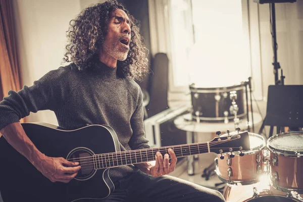 Kreativer Musiker singt und spielt Gitarre im Studio . — Stockfoto