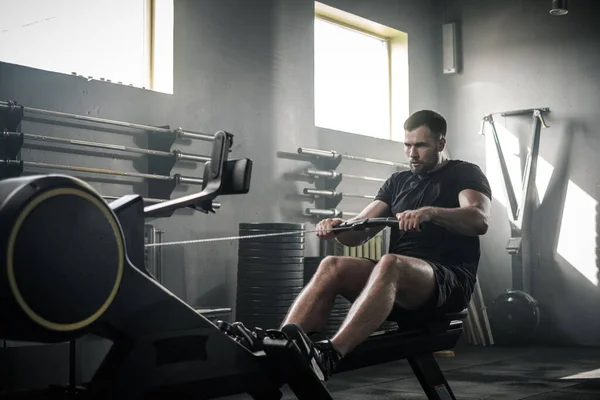 Handsome Man Has Arms Workout On Rowing Machine . — Stok Foto