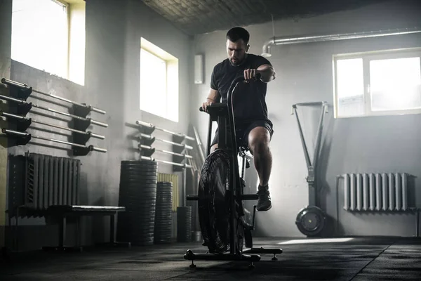 Active Male heeft workout op stationaire fiets . — Stockfoto