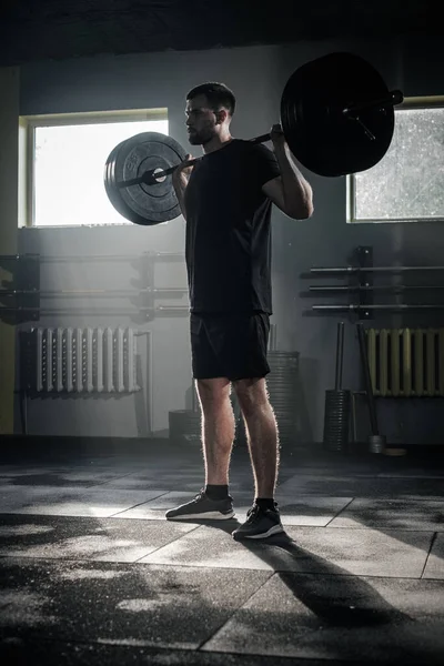 O homem muscular faz o exercício duro dos braços com barra . — Fotografia de Stock