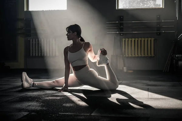 Atletik Bayan Yoga pozlarıyla bacaklarını esnet . — Stok fotoğraf