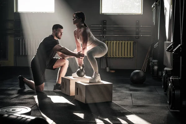 Fitness Girl Do Squats Under Supervision of Coach .