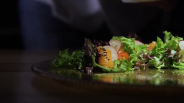 Şef düzeltiyor ve müşterilere hizmet öncesi yemek süsleyen