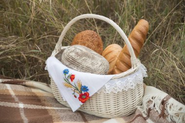 Çayırdaki sepetin içinde bir sürü taze ekmek yatıyor.