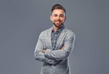 Zarif bir gri elbiseli şık adam gülümsüyor, ile poz silah bir kameraya bakarak bir stüdyoda geçti.