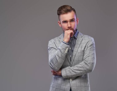 Zarif bir gri ceketli dalgın yakışıklı şık adamı çene üzerinde el ile poz.