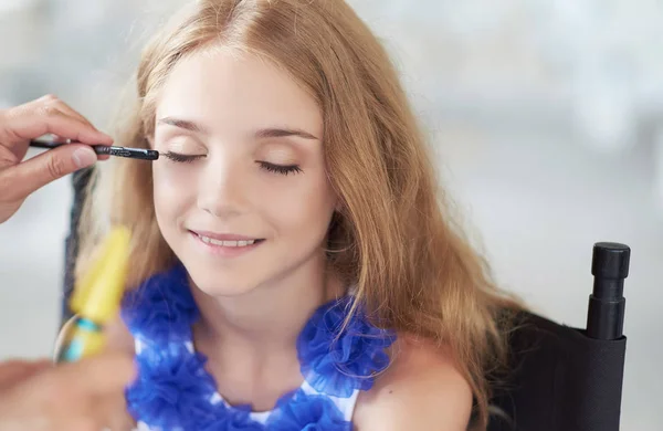 Estilista fazendo a maquiagem para um belo modelo de menina . — Fotografia de Stock