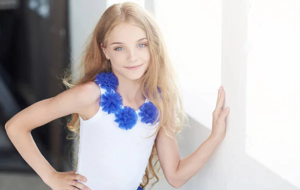 Portrait d'une petite fille heureuse mannequin avec un sourire charmant posant dans un studio . — Photo