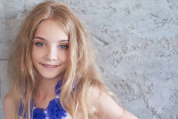 Porträtt av en glad liten tjej modell med charmiga leende poserar i en studio. — Stockfoto