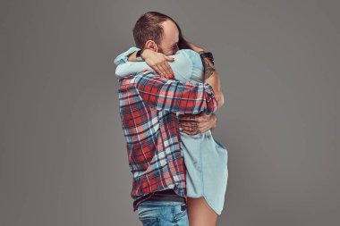 Çekici çift, sakallı adam ve esmer kız bir stüdyoda sarılma.