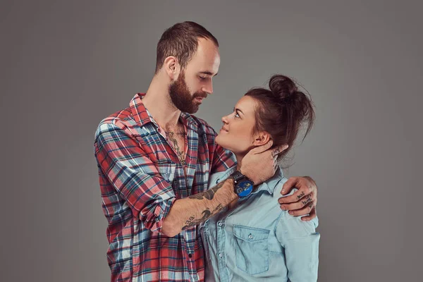 Atractiva pareja, hombre barbudo y chica morena abrazándose en un estudio . — Foto de Stock