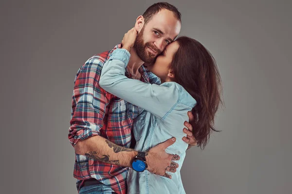 Aantrekkelijke paar, bebaarde man en brunette meisje knuffelen in een studio. — Stockfoto