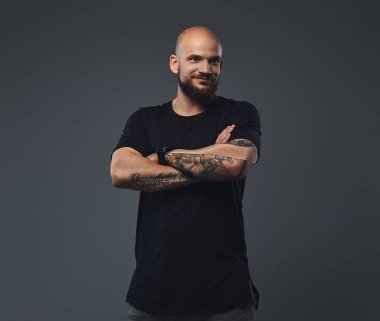 Yakın çekim portre siyah t-shirt içinde yakışıklı bir sakallı sporcu ile poz silah bir stüdyoda geçti.