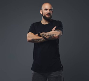 Yakın çekim portre siyah t-shirt içinde yakışıklı bir sakallı sporcu ile poz silah bir stüdyoda geçti.