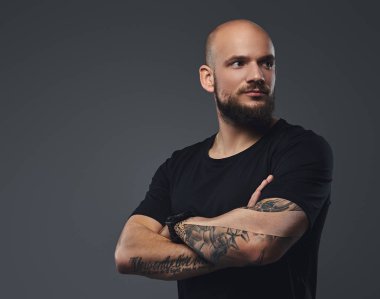 Yakın çekim portre siyah t-shirt içinde yakışıklı bir sakallı sporcu ile poz silah bir stüdyoda geçti.