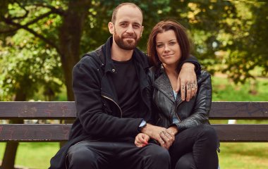 Bir parkta bir bankta oturmuş çekici modern Çift.