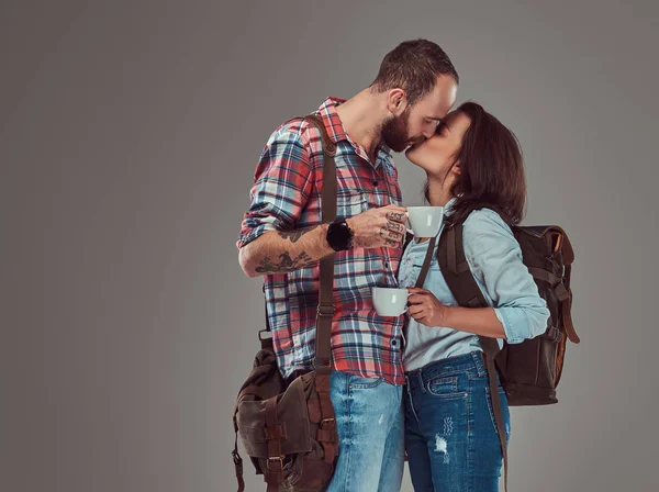 Feliz casal de turistas beijando enquanto segurando copos de um café . — Fotografia de Stock