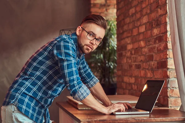 Szép diák dolgozik a laptop számítógép, egy szobában a padláson belső flanel ing. — Stock Fotó