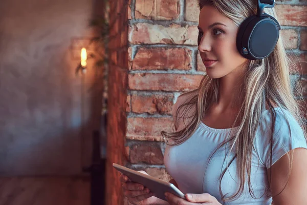 Joven Mujer Rubia Escuchando Música Sostiene Una Tableta Digital Mientras — Foto de Stock