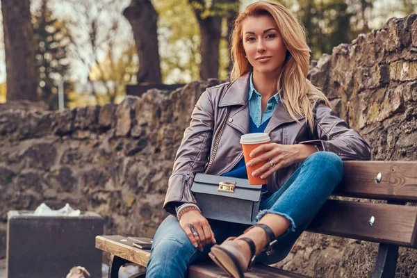 Fashionabla Blond Kvinna Slappnar Utomhus Dricka Takeaway Kaffe Sittande Bänken — Stockfoto