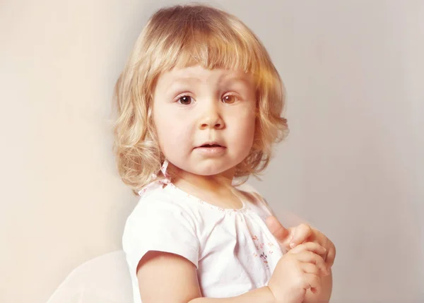 Portrét roztomilé děvčátko v bílých šatech na bílém pozadí — Stock fotografie