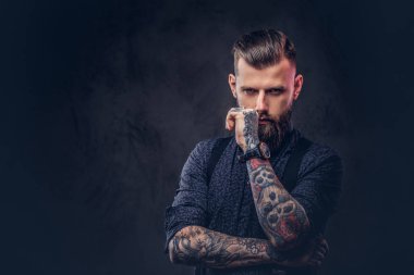 Mavi bir gömlek ve pantolon askısı, çene bir stüdyoda el ile ayakta dalgın yakışıklı eski moda hippi.