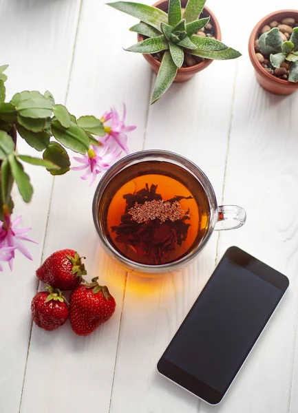 Närbild Glas Kopp Röda Jordgubbar Smartphone Och Blommor Krukor Trä — Stockfoto