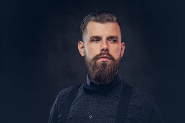 Yakışıklı bir eski moda hippi bir stüdyoda poz mavi bir gömlek ve pantolon askısı, portresi.